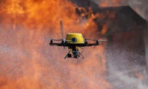 immagine di un drone antincednio giallo che trasporta l'acqua dove si trova un incednio