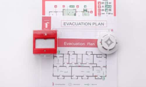 esempio piano di evacuazione, con ai lati l'allarme di evacuazione e un rilevatore di fumo