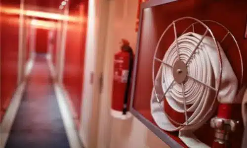 foto di una manichetta antincendio vicino ad un estintore a muro