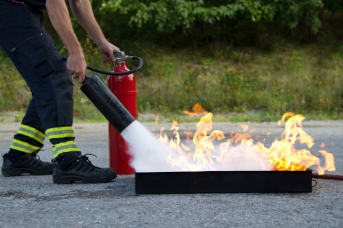 foto di un addetto alla formazione che spiega come spegnere un fuoco con un estintore