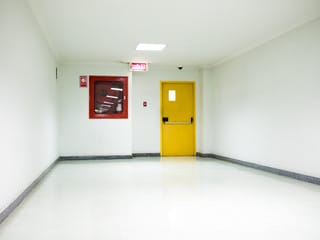 Corridoio con una porta antincendio gialla con apertura antipanico